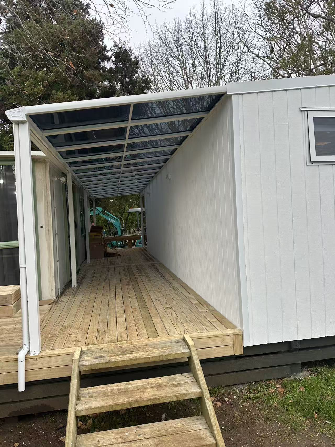 White aluminium lean-to canopy installed over a long timber deck
