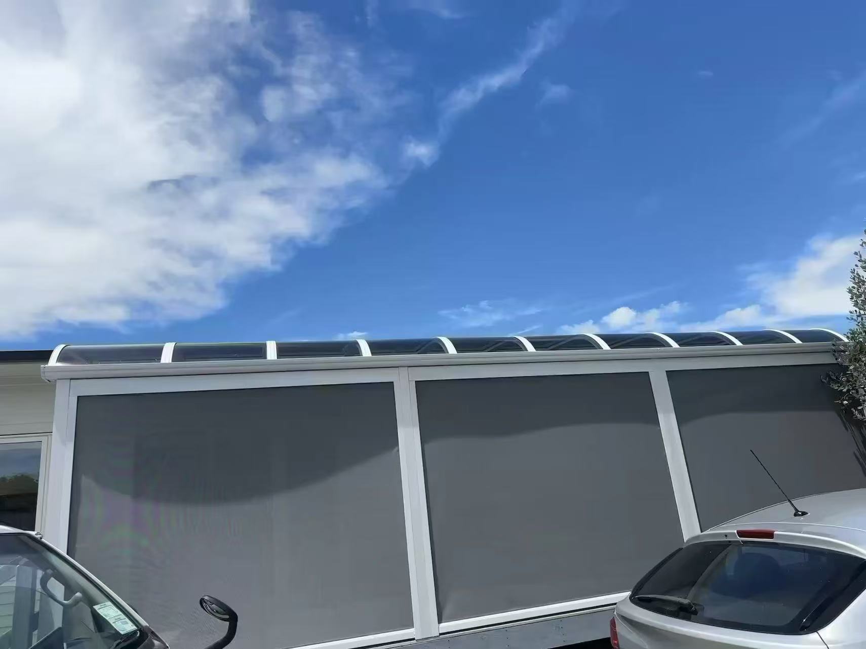 Track-guided outdoor screens fitted to a curved patio canopy