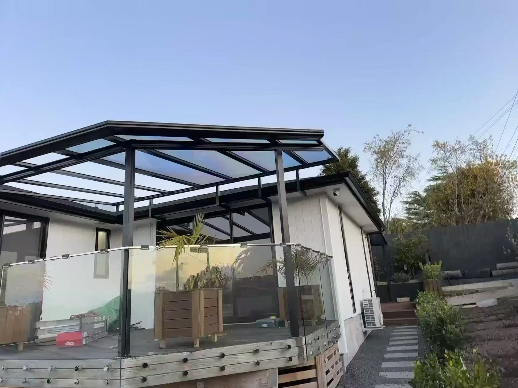 Aluminium patio canopy with a polycarbonate roof over an Auckland timber deck