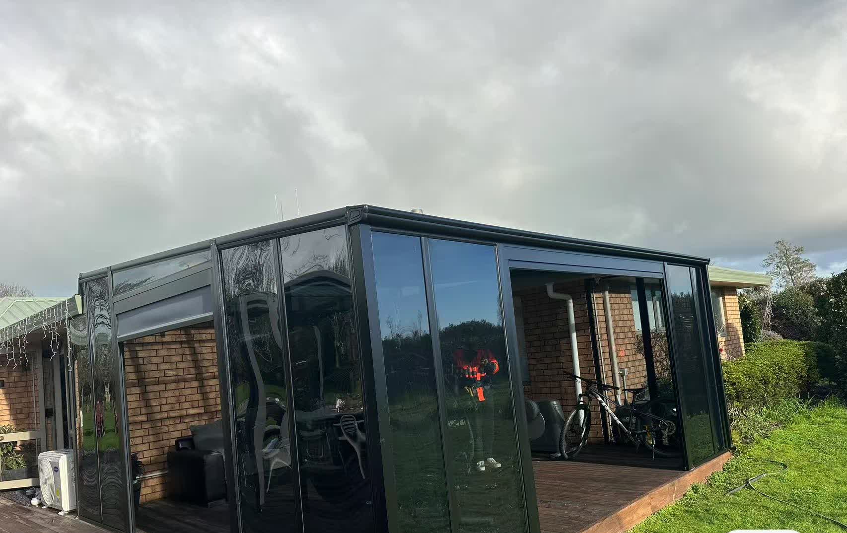 Custom black aluminium sunroom installed beside an Auckland home